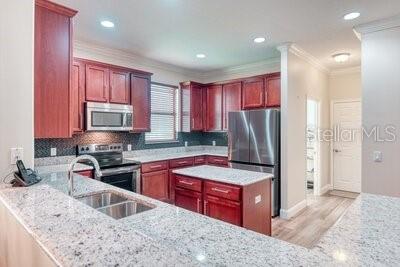 824 Ebb Tide Lane Kissimmee, FL 34759 - Photo 5 of 60 a kitchen with stainless steel appliances granite countertop a sink stove and refrigerator