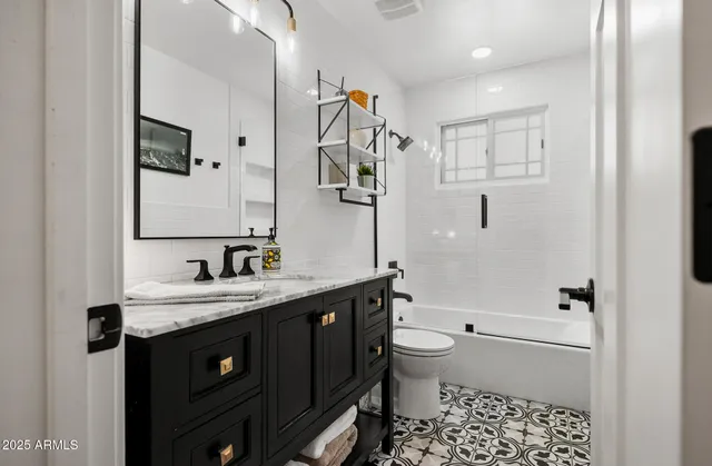 a bathroom with a granite countertop sink toilet and shower