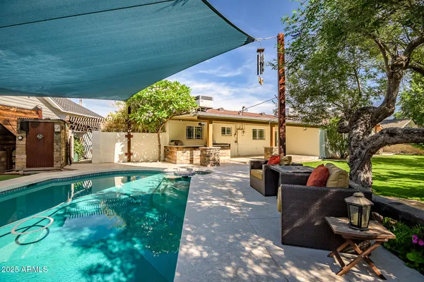 a backyard of a house with plants and large tree