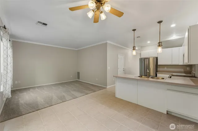 a view of a kitchen with a sink and chandelier fan
