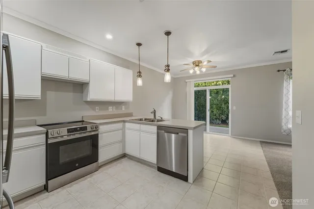 a kitchen with stainless steel appliances granite countertop a stove a sink and a refrigerator
