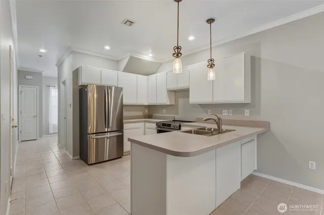 a kitchen with stainless steel appliances granite countertop a refrigerator a sink and a stove