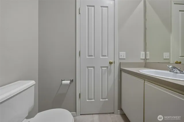 a bathroom with a toilet a sink and mirror