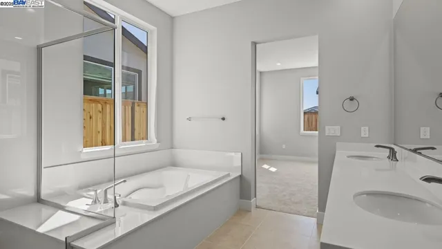 a bathroom with a granite countertop tub sink and mirror