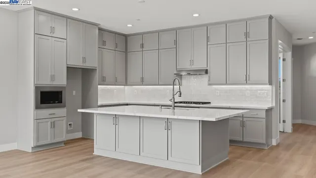 a kitchen with kitchen island granite countertop white cabinets and stainless steel appliances