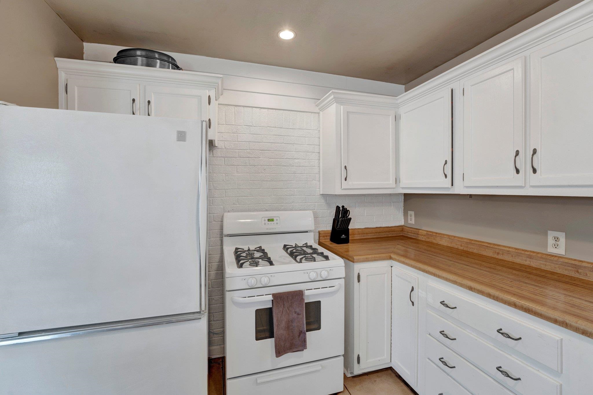 4891 Flamingo Road Memphis, TN 38117 - Photo 17 of 34 a kitchen with granite countertop white cabinets and white appliances
