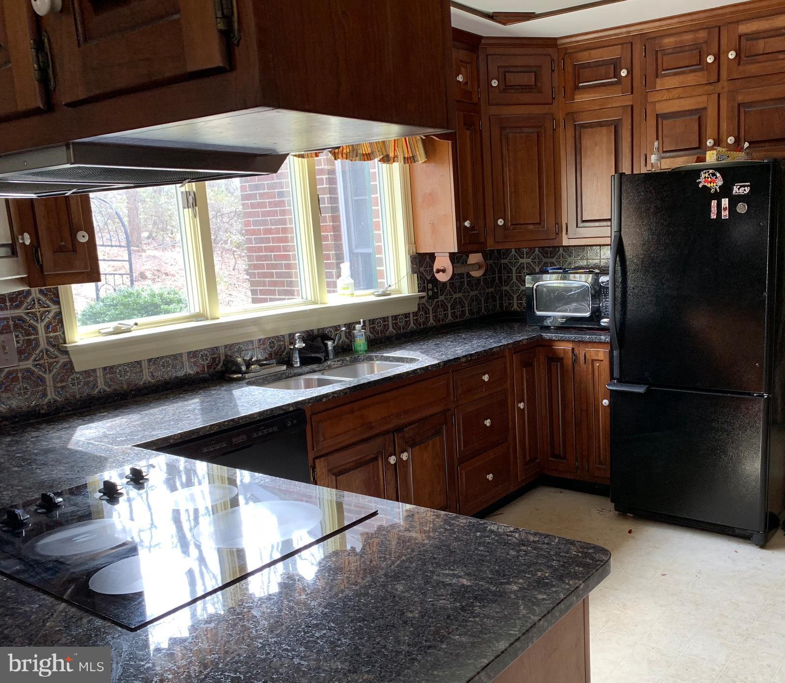 7603 Irongate Lane Frederick, MD 21702 - Photo 14 of 43 a kitchen with a refrigerator a sink and wooden cabinets