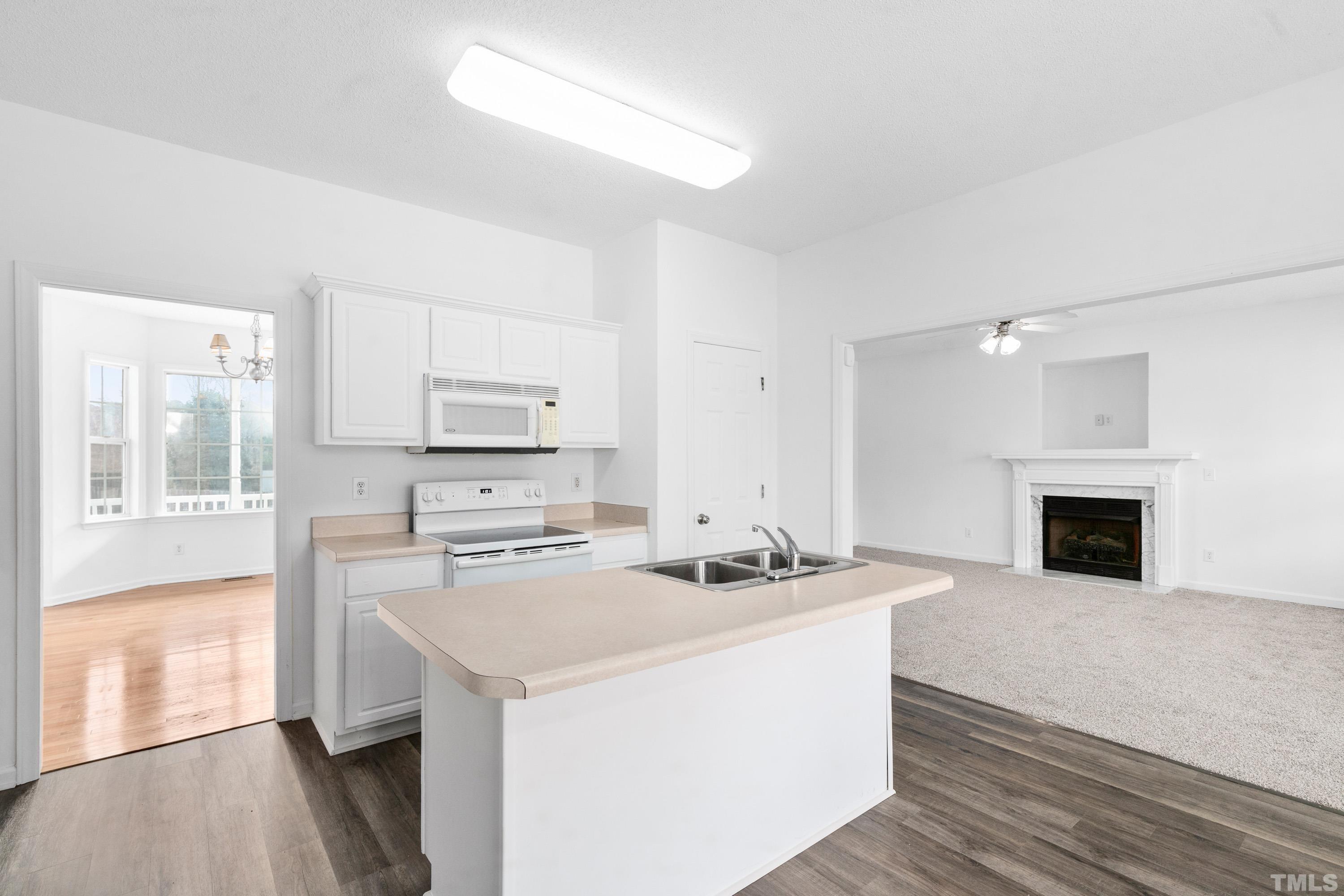 110 Saddle Ridge Drive Willow Spring, NC 27592 - Photo 13 of 32 a kitchen with stainless steel appliances kitchen island a white cabinets and wooden floor
