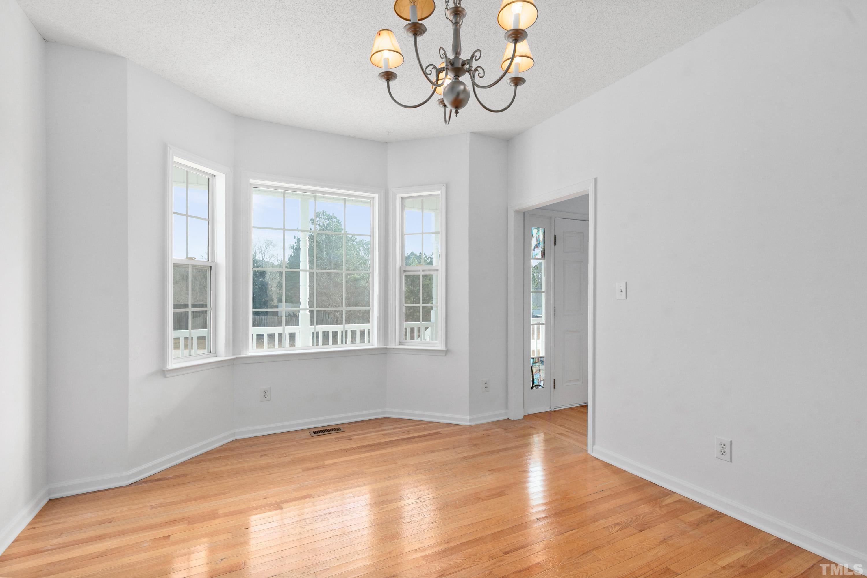 110 Saddle Ridge Drive Willow Spring, NC 27592 - Photo 15 of 32 a view of an empty room with wooden floor and a window