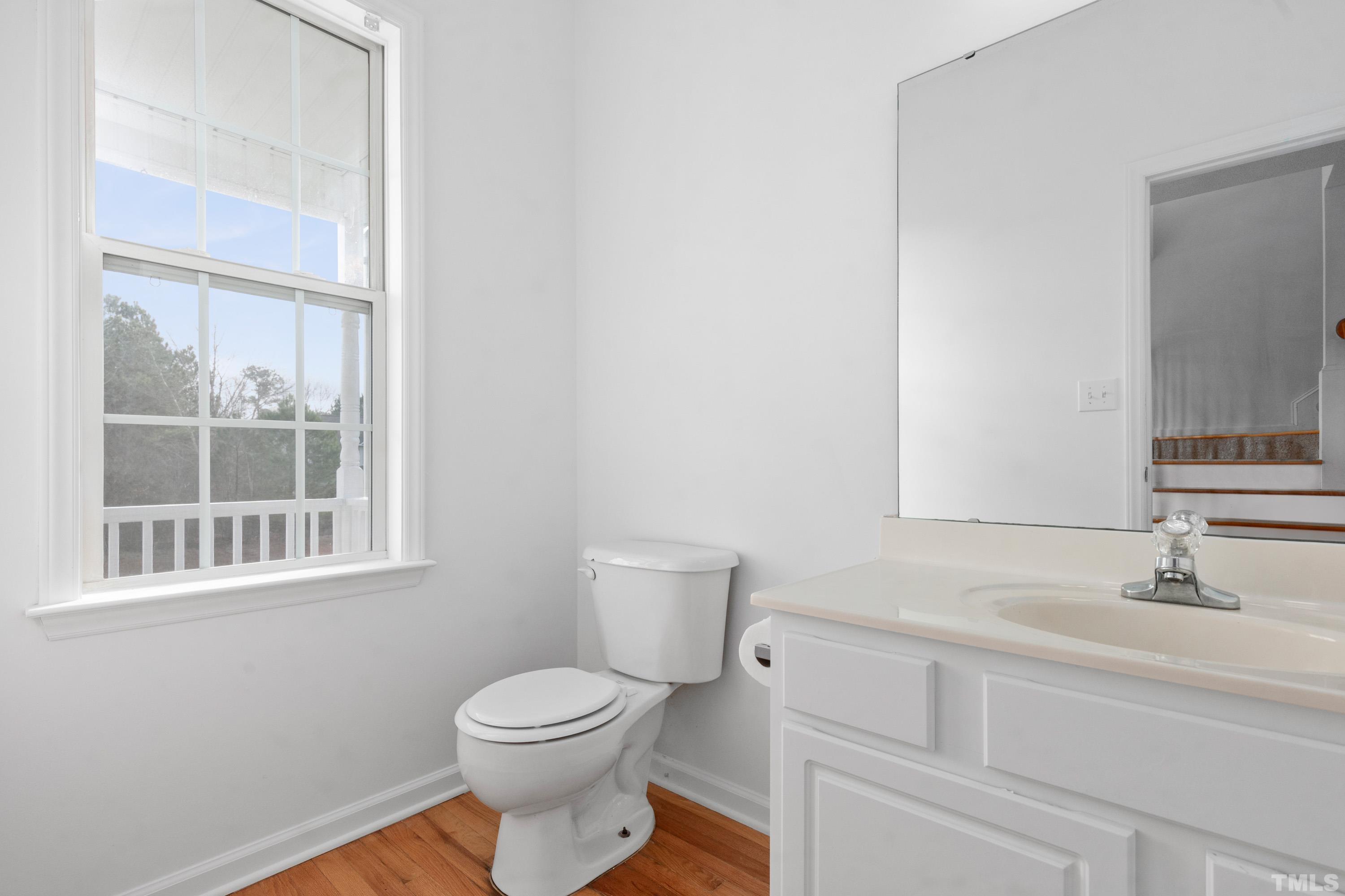 110 Saddle Ridge Drive Willow Spring, NC 27592 - Photo 17 of 32 a bathroom with a toilet a sink a vanity and a window