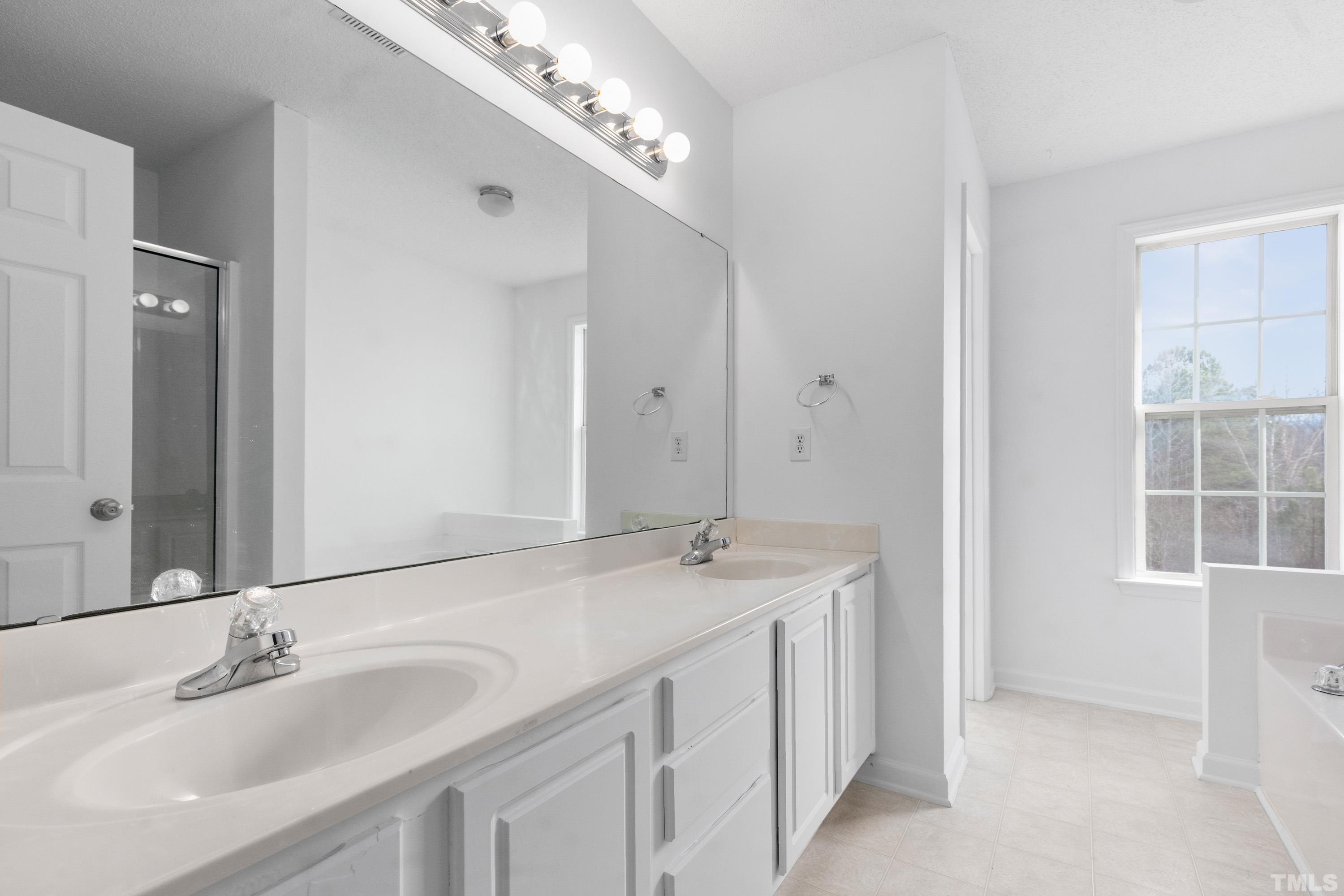 110 Saddle Ridge Drive Willow Spring, NC 27592 - Photo 20 of 32 a bathroom with a sink double vanity and a mirror