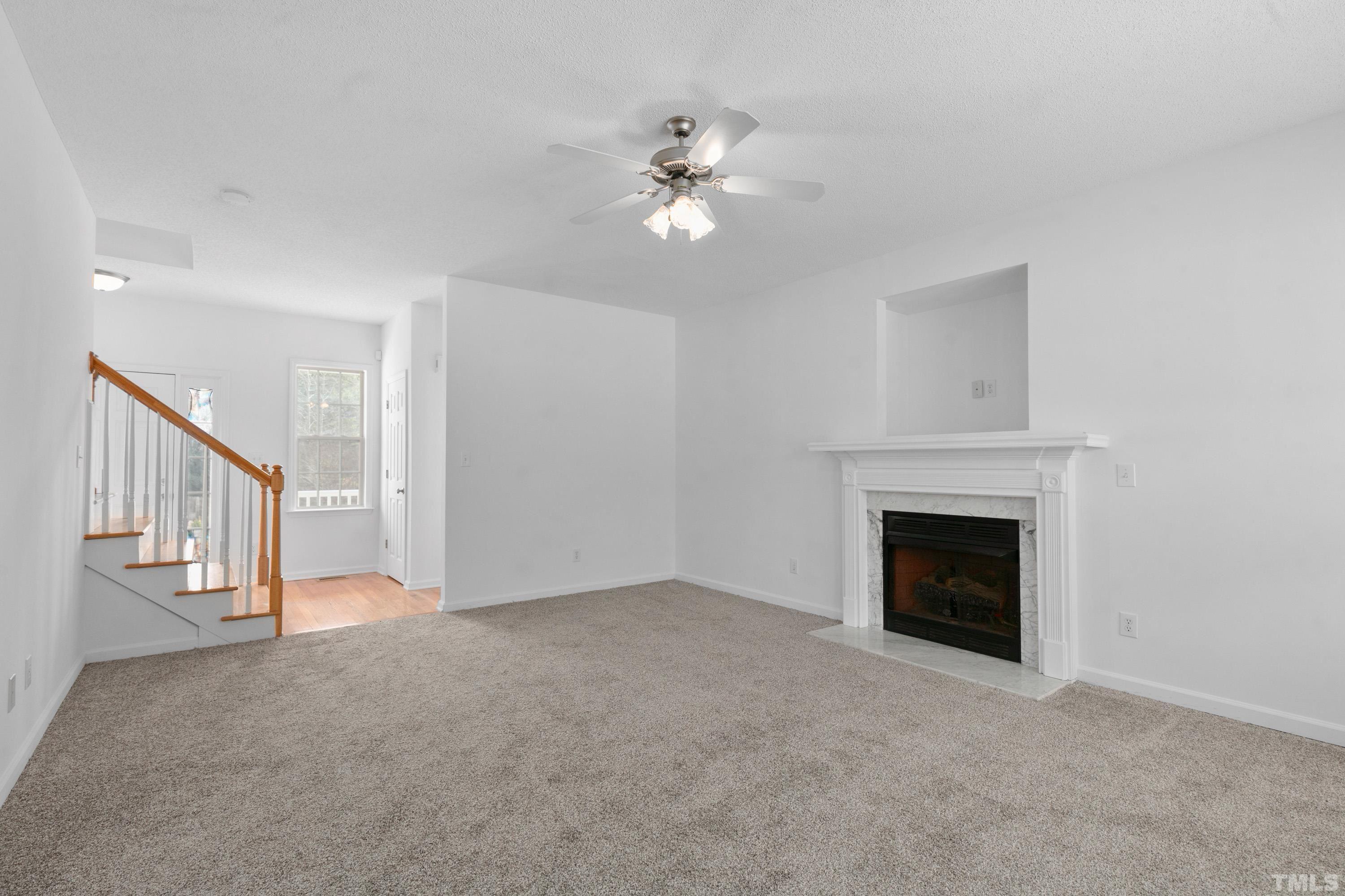 110 Saddle Ridge Drive Willow Spring, NC 27592 - Photo 9 of 32 a view of an empty room with chandelier fan and fire place