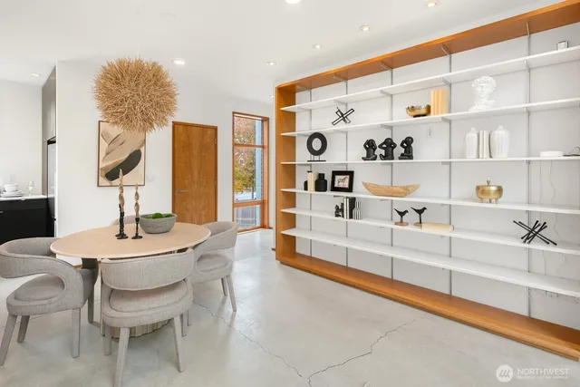 a large white kitchen with a large window and chairs