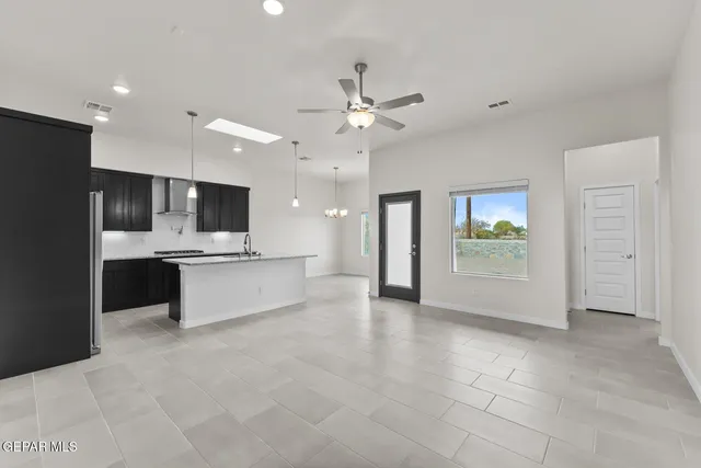 a large kitchen with a refrigerator and a stove top oven