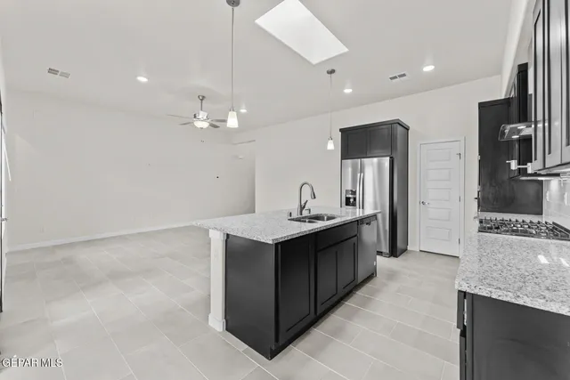 a large kitchen with kitchen island a sink stainless steel appliances and cabinets