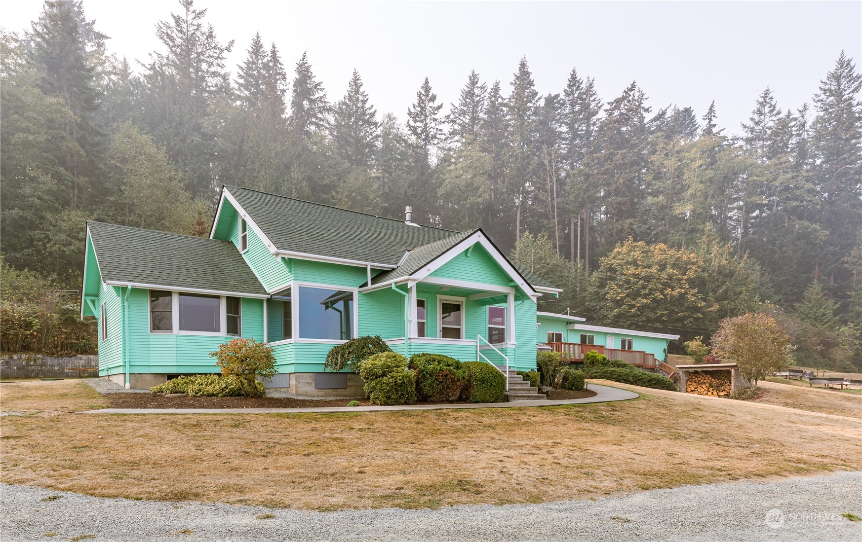 4736 Sharpe Road Anacortes, WA 98221 - Photo 3 of 40 a front view of a house with a garden and trees