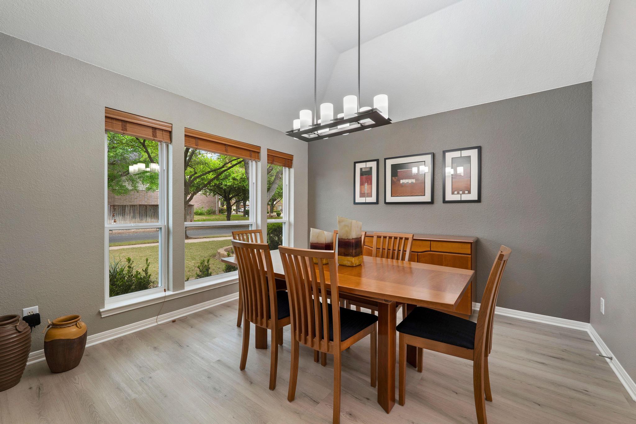 13231 Armaga Springs Road Austin, TX 78727 - Photo 14 of 36 Dining room featuring lofted ceiling, light wood-style flooring, hanging lights, and a textured wall