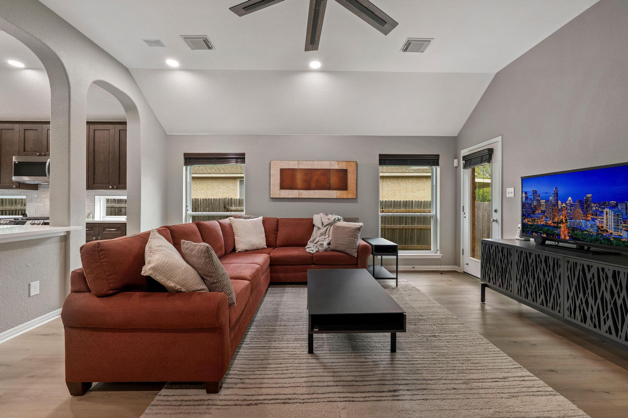 13231 Armaga Springs Road Austin, TX 78727 - Photo 16 of 36 Living room with light wood-style floors, vaulted ceiling, arched walkways, ceiling fan, and recessed lighting