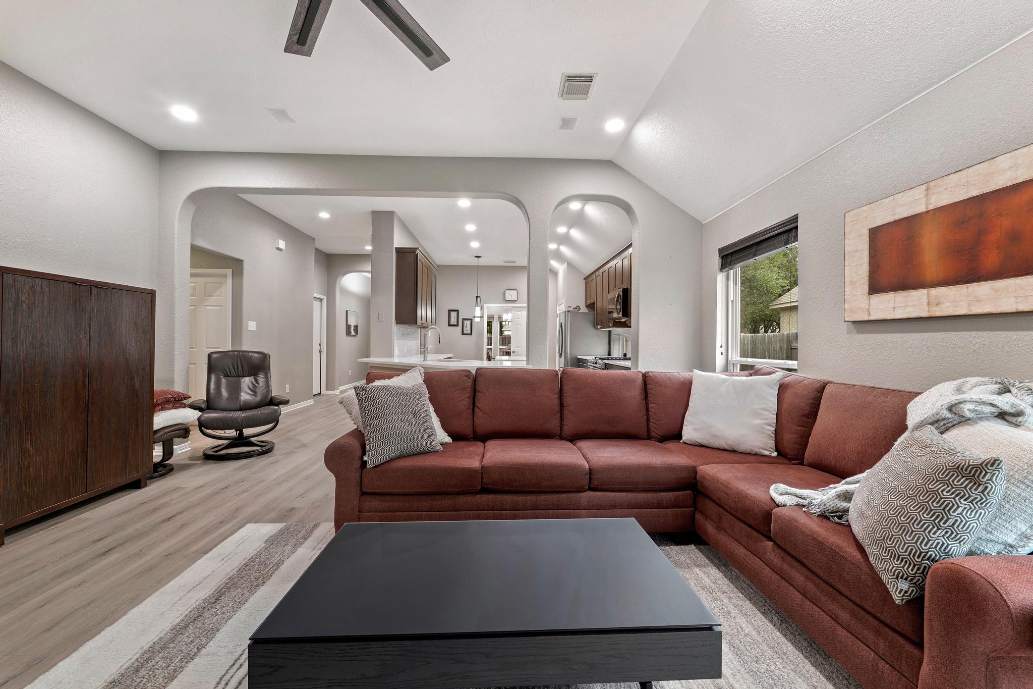 13231 Armaga Springs Road Austin, TX 78727 - Photo 20 of 36 Living room featuring light wood finished floors, vaulted ceiling, a ceiling fan, recessed lighting, and arched walkways