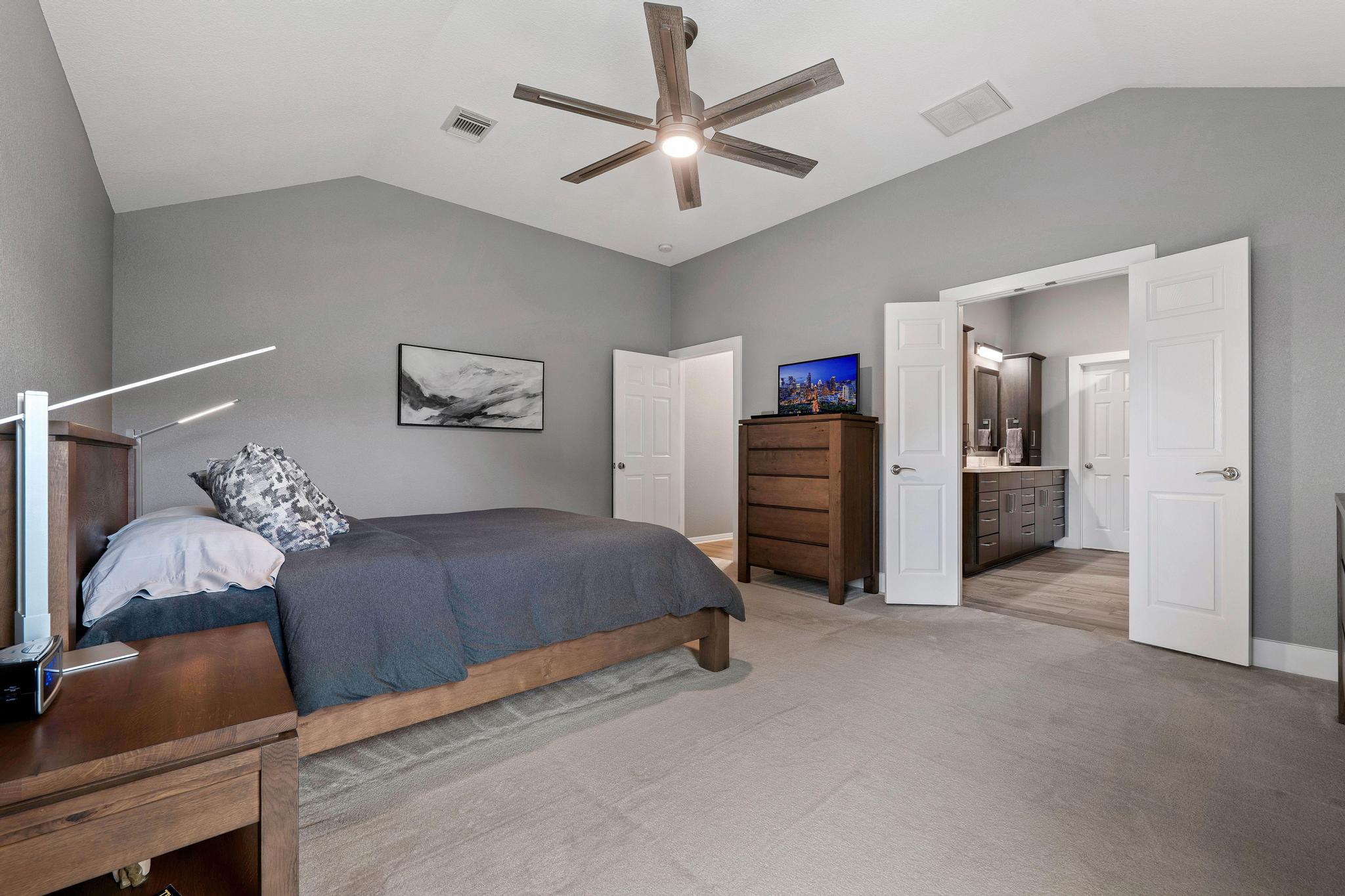 13231 Armaga Springs Road Austin, TX 78727 - Photo 24 of 36 Carpeted bedroom with a ceiling fan and ensuite bathroom