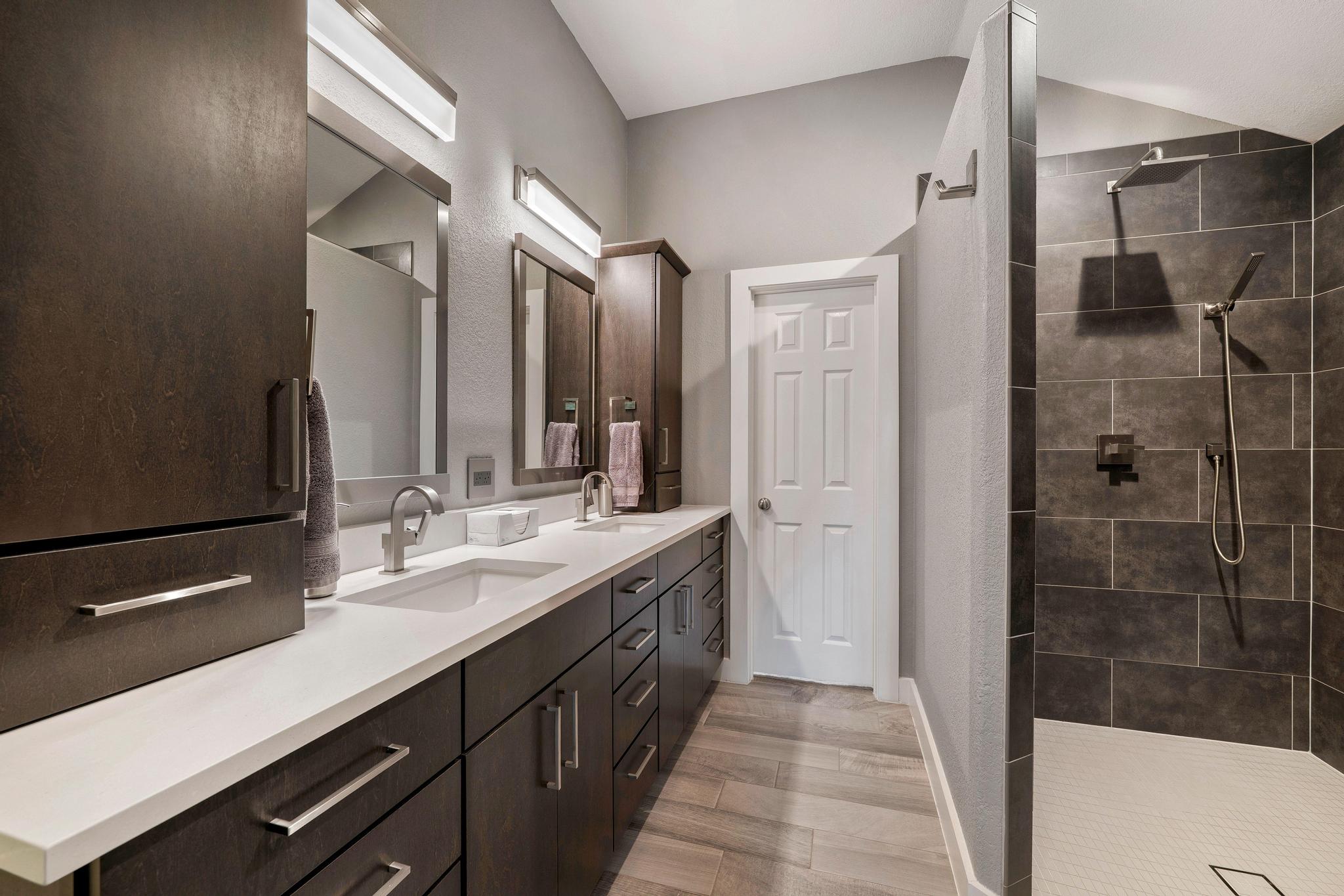 13231 Armaga Springs Road Austin, TX 78727 - Photo 26 of 36 Full bathroom featuring double vanity, a walk in shower, light wood finished floors, and lofted ceiling