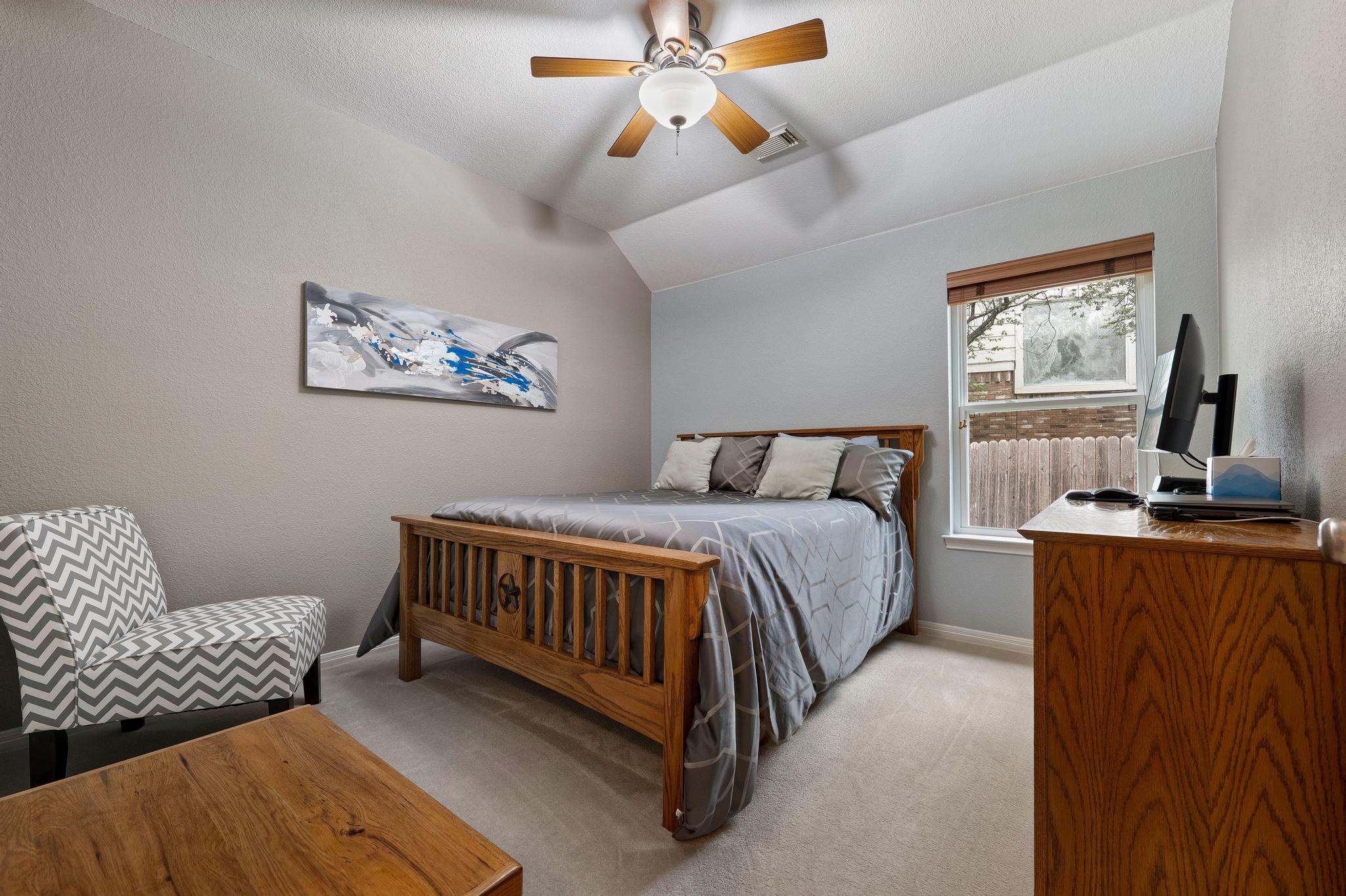 13231 Armaga Springs Road Austin, TX 78727 - Photo 29 of 36 Bedroom with light carpet, vaulted ceiling, a ceiling fan, and a textured wall