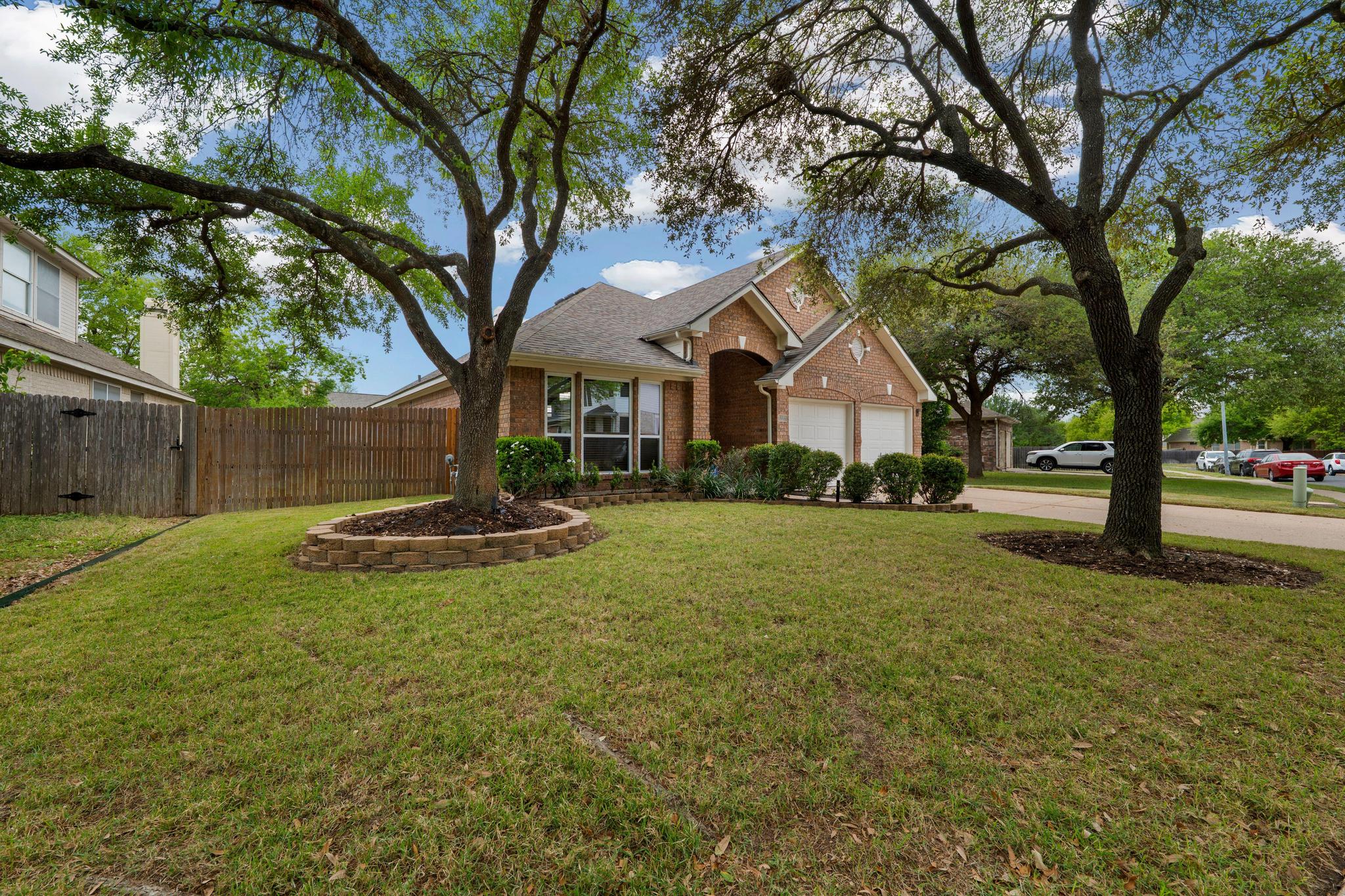 13231 Armaga Springs Road Austin, TX 78727 - Photo 7 of 36 View of front of home with brick siding, concrete driveway, and an attached garage