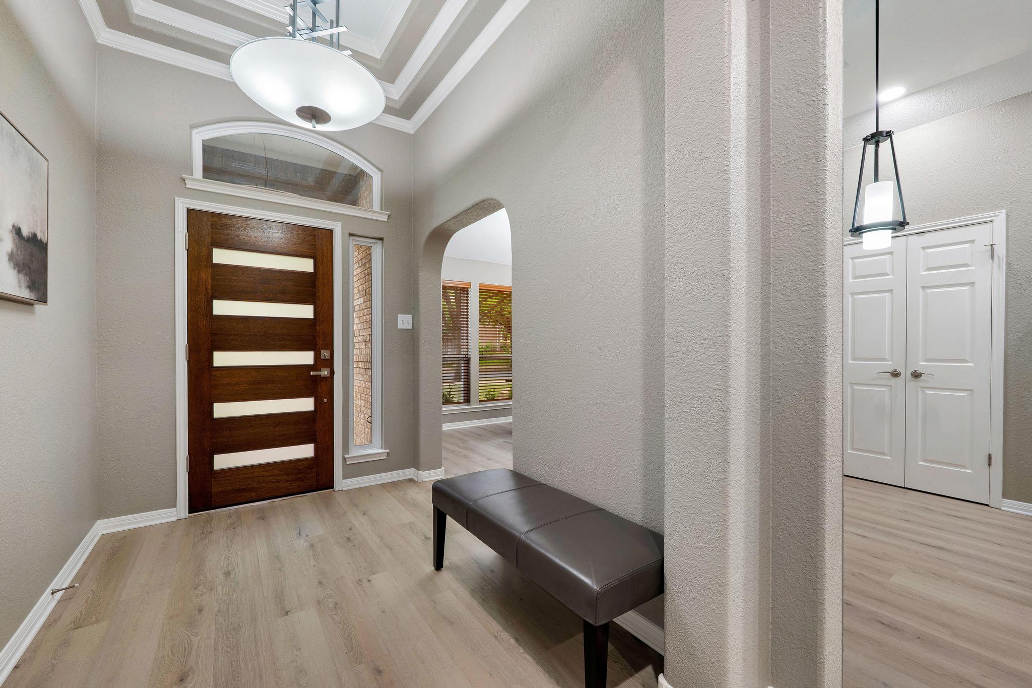 13231 Armaga Springs Road Austin, TX 78727 - Photo 9 of 36 Entrance foyer with light wood finished floors, arched walkways, crown molding, and a high ceiling