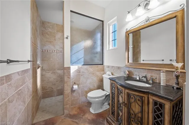 a bathroom with a granite countertop sink a toilet and a mirror