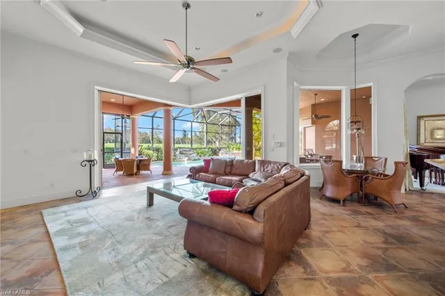 a living room with furniture ceiling fan and a large window