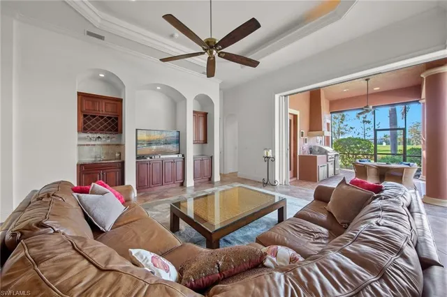 a living room with furniture ceiling fan and a large window