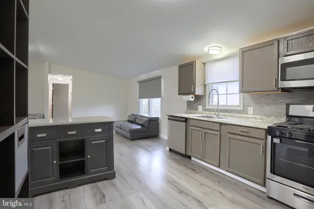 a kitchen with granite countertop a stove top oven sink and cabinets