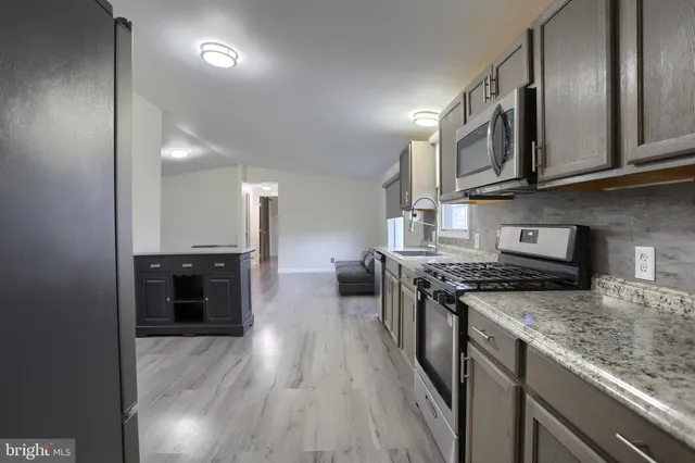 a kitchen with stainless steel appliances granite countertop a stove and a sink