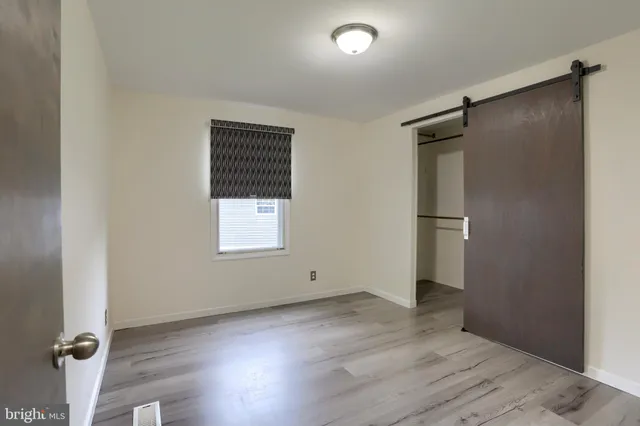 an empty room with wooden floor and a window