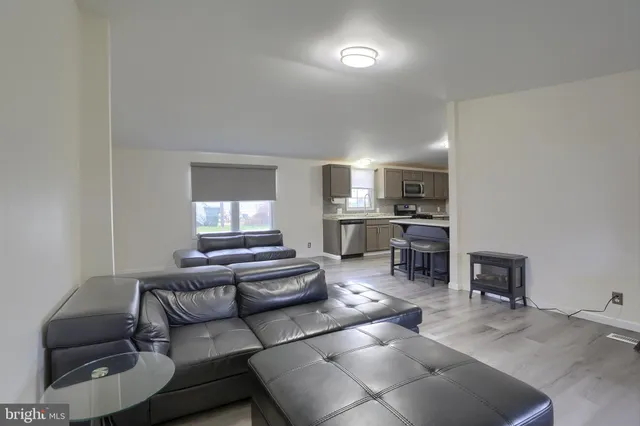 a living room with furniture and a kitchen