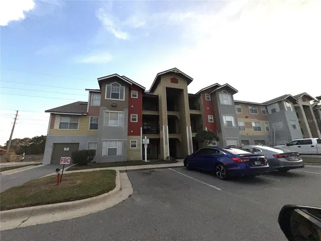 a front view of a house with cars parked