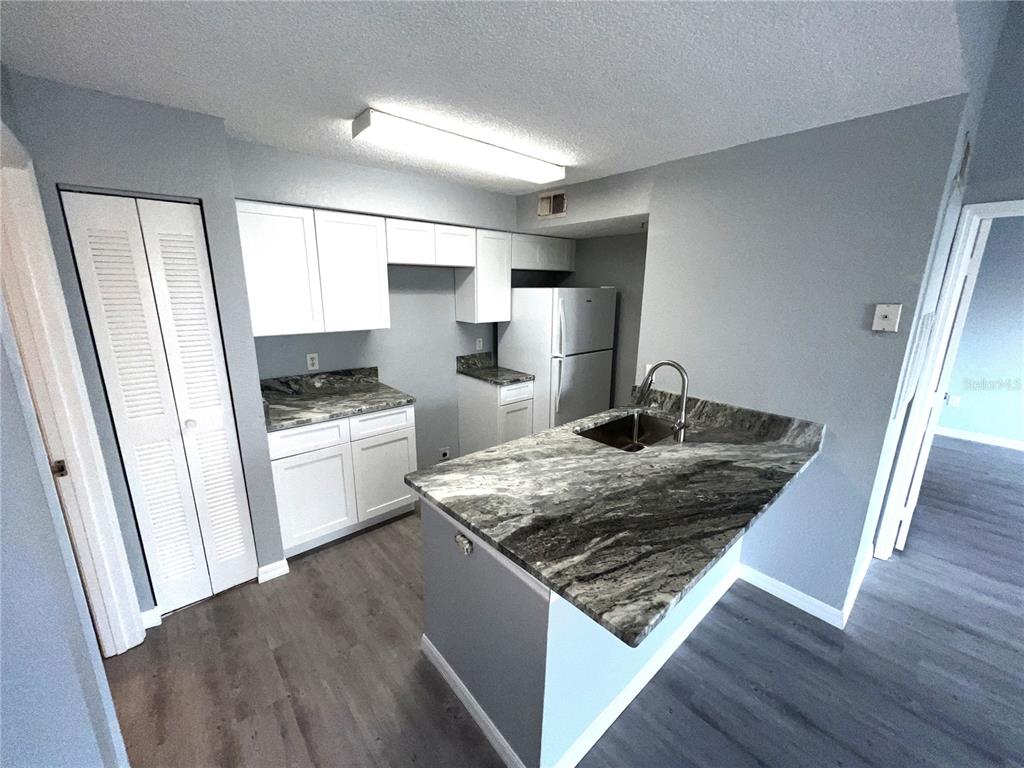 2202 Key W Court, Unit 638 Kissimmee, FL 34741 - Photo 6 of 11 a kitchen with white cabinets and appliances