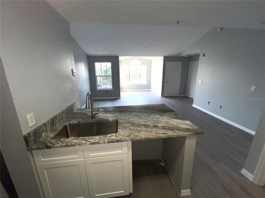 2202 Key W Court, Unit 638 Kissimmee, FL 34741 - Photo 7 of 11 a kitchen with sink cabinets and window