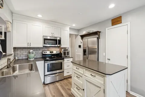 a kitchen with granite countertop a sink stove and refrigerator
