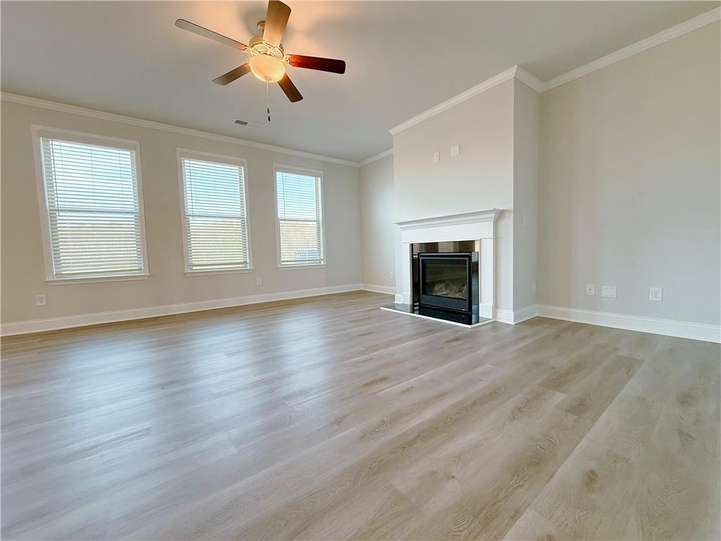 1450 Sunny Valley Lane Braselton, GA 30517 - Photo 5 of 24 an empty room with wooden floor fireplace and windows