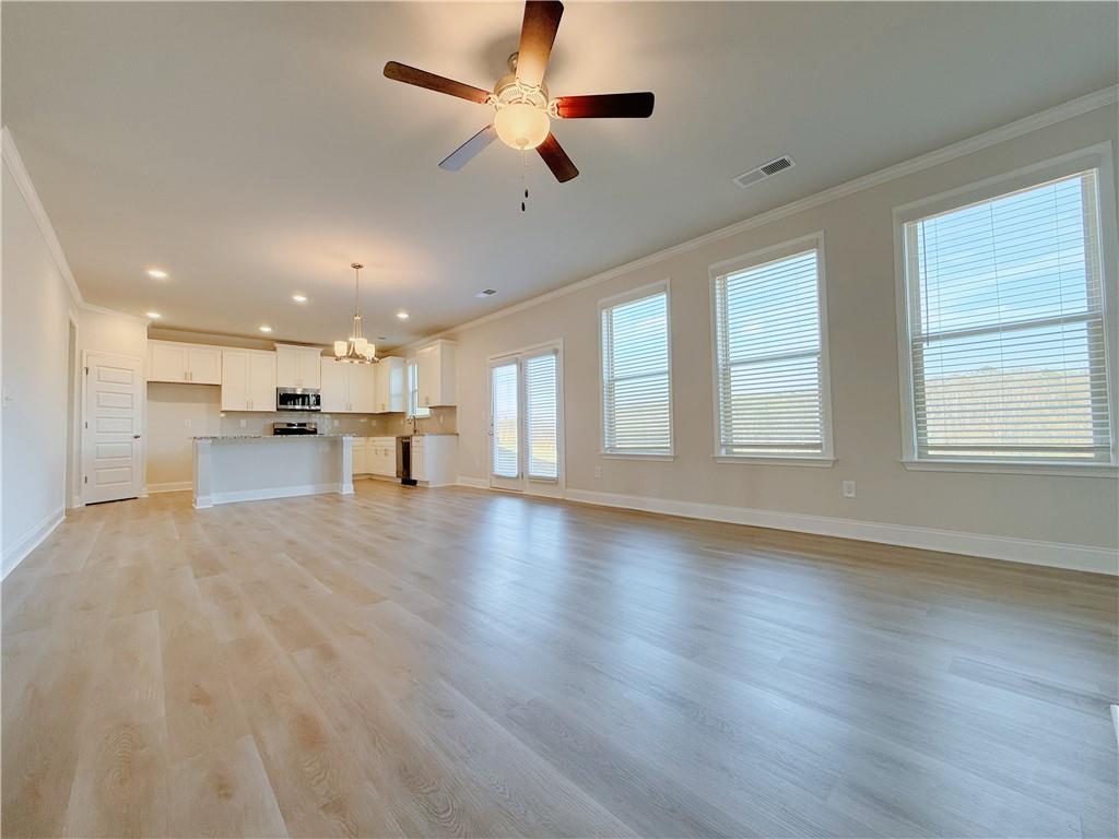 1450 Sunny Valley Lane Braselton, GA 30517 - Photo 6 of 24 a view of a kitchen with a stove cabinets a ceiling fan and wooden floor