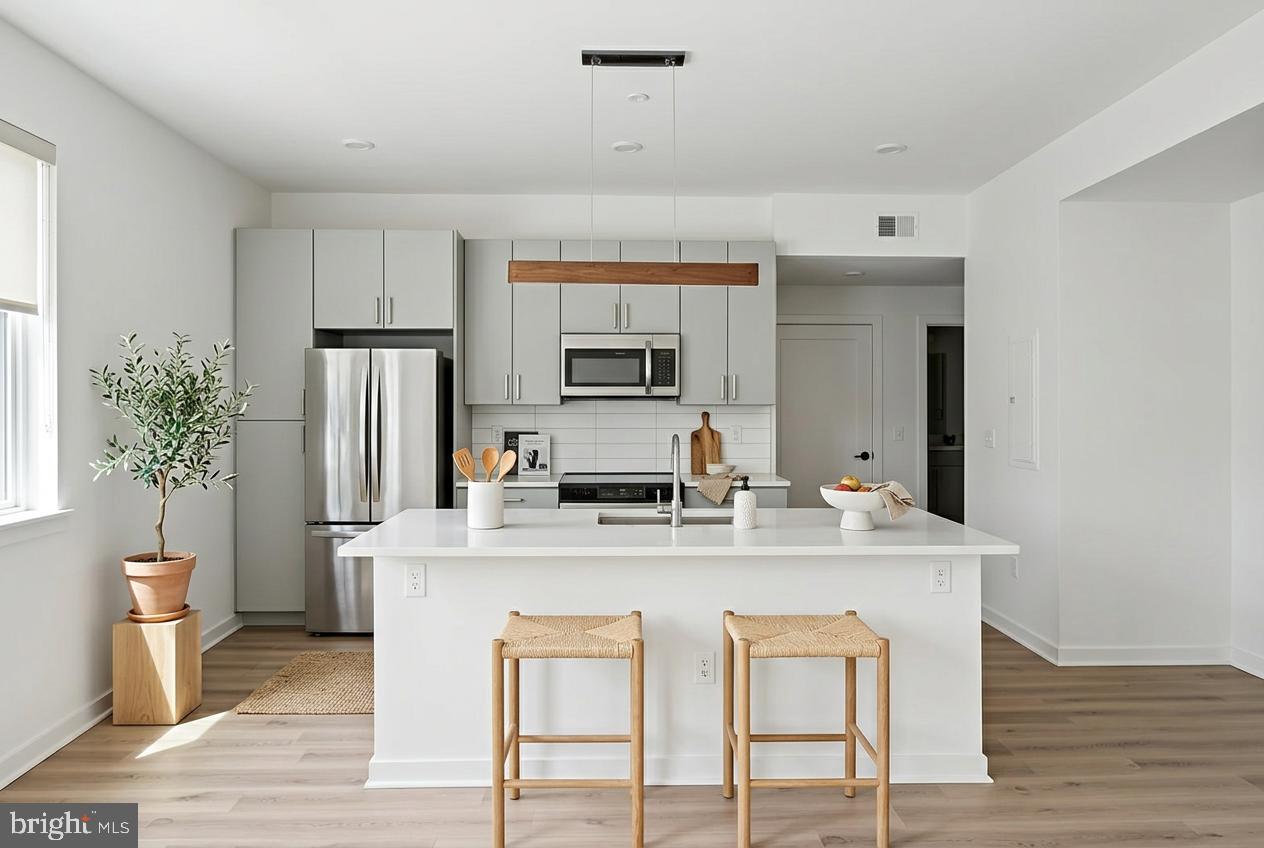 a kitchen with stainless steel appliances granite countertop a sink a stove a refrigerator and a refrigerator