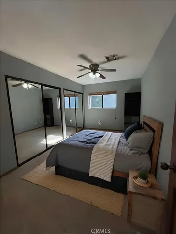 a bedroom with a bed window and a ceiling fan