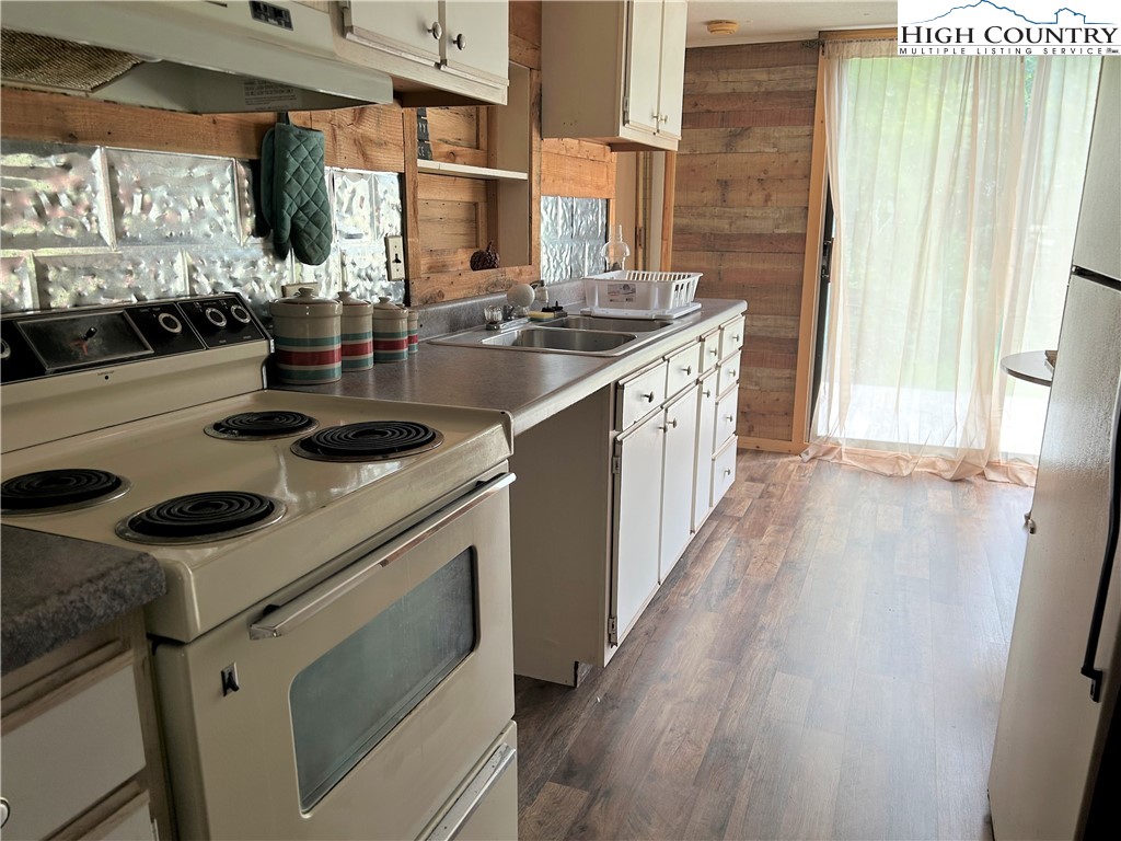 294 Walter Blevins Road Lansing, NC 28643 - Photo 3 of 15 a kitchen with a sink stove and cabinets