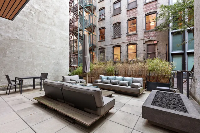 a patio with patio couch and outdoor seating