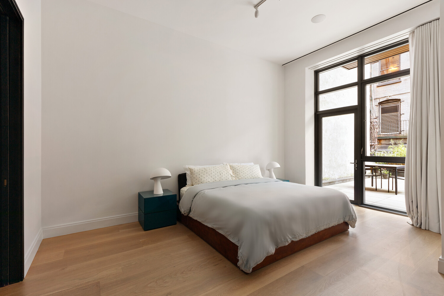 45 Great Jones Street, Unit 2 Manhattan, NY 10012 - Photo 5 of 11 a bedroom with a bed and a large window