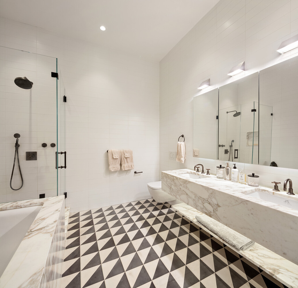 45 Great Jones Street, Unit 2 Manhattan, NY 10012 - Photo 6 of 11 a bathroom with a double vanity sink a mirror and a shower