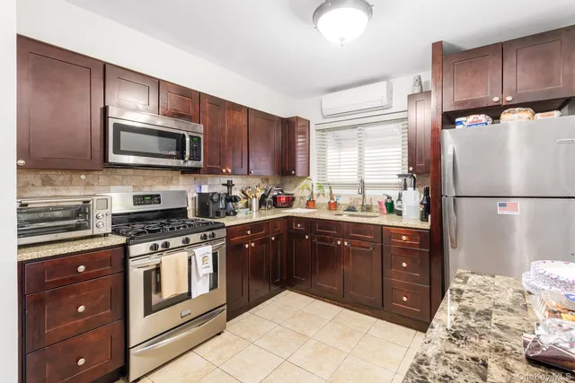a kitchen with granite countertop wooden cabinets and stainless steel appliances