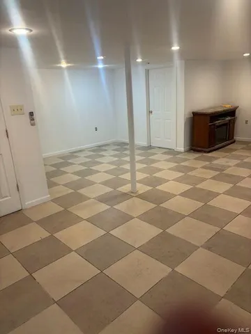 a view of a livingroom with wooden floor and a refrigerator