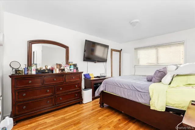 a bedroom with a bed and a mirror on dresser